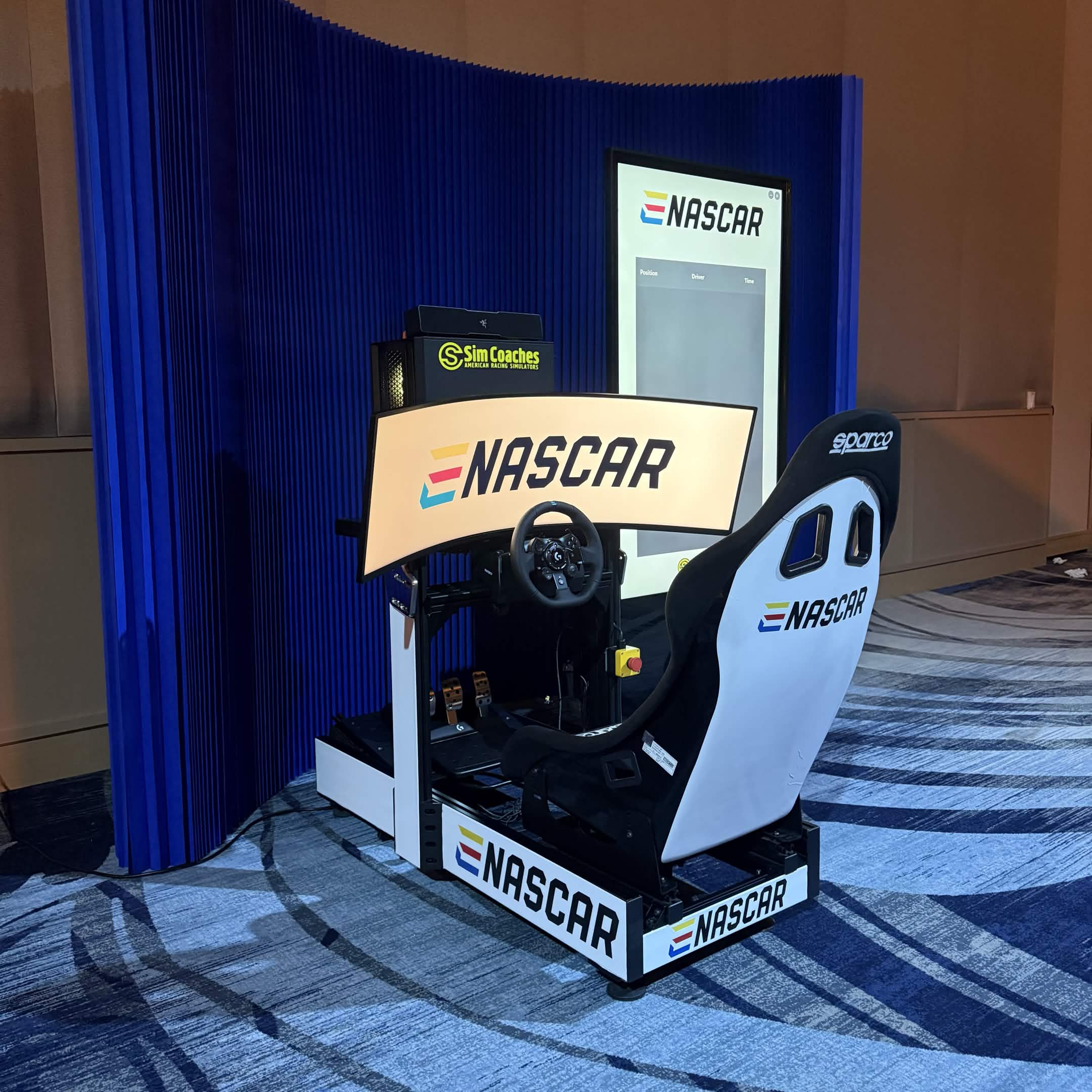ENASCAR event racing simulator activation with premium blue booth backdrop